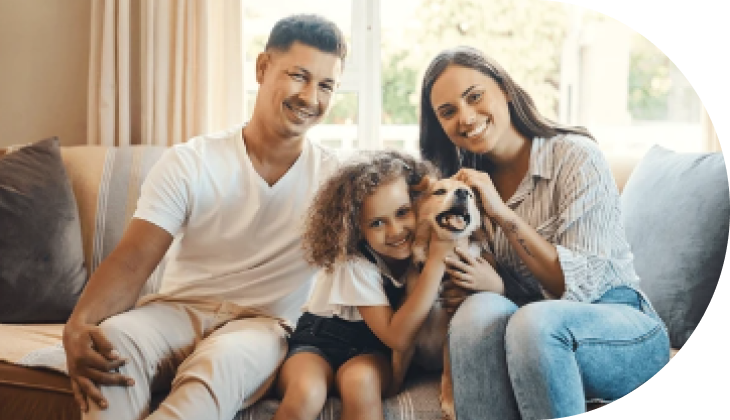 man, woman, child, and dog sitting on couch